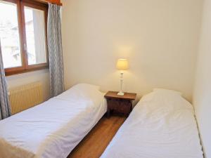 two beds in a room with a lamp and a window at Apartment Villars Soleil A27 by Interhome in Villars-sur-Ollon +21 photos