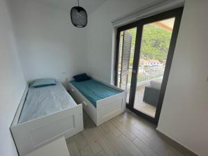 1 dormitorio con 2 camas y ventana grande en Apartmani Pulić, en Senj