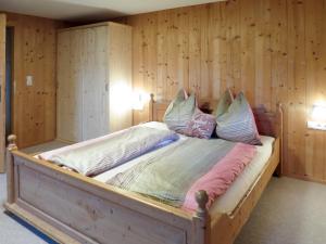 a bedroom with a large bed with wooden walls at Chalet Alm Chalet by Interhome in Gattererberg +43 photos
