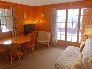 Zimmer mit einem Schreibtisch und einem Tisch mit einem TV in der Unterkunft Apartment Le Brévent 4 by Interhome in Villars-sur-Ollon