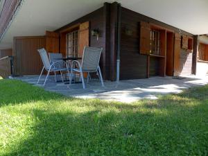 eine Terrasse mit Stühlen und einem Tisch auf einem Haus in der Unterkunft Apartment Le Brévent 4 by Interhome in Villars-sur-Ollon