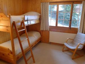 1 Schlafzimmer mit 2 Etagenbetten und einem Stuhl in der Unterkunft Apartment Le Brévent 4 by Interhome in Villars-sur-Ollon