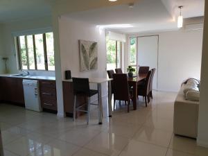 a kitchen and dining room with a table and chairs at Reef Terraces on St Crispins - Villa 2 in Port Douglas