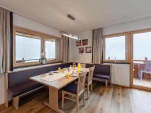 jadalnia ze stołem, krzesłami i oknami w obiekcie Apartment Apart Wurm-2 by Interhome w mieście Stummerberg