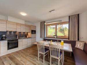kuchnia i jadalnia ze stołem i krzesłami w obiekcie Apartment Apart Wurm-2 by Interhome w mieście Stummerberg