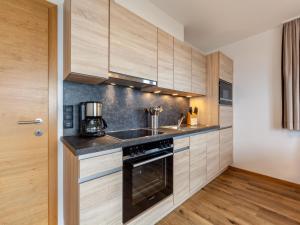 kuchnia z drewnianymi szafkami i kuchenką w obiekcie Apartment Apart Wurm-2 by Interhome w mieście Stummerberg