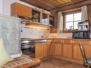 eine Küche mit Holzschränken und einem Waschbecken in der Unterkunft Chalet Auhäusl by Interhome in Fügenberg