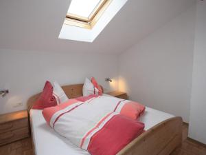 a bedroom with a bed with red and white pillows at Apartment Gasteighof-1 by Interhome in Kapfing