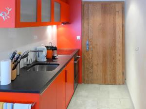 a kitchen with a sink and a wooden door at Apartment Rütschi-1 by Interhome in Zermatt