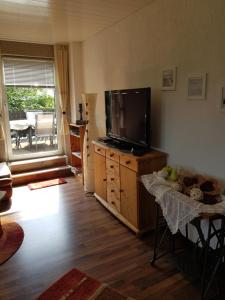 ein Wohnzimmer mit einem Flachbild-TV und einem Tisch in der Unterkunft Apartment Bergisches Land in Wermelskirchen
