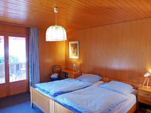 a bedroom with a bed in a wooden wall at Holiday Home Chalet Marietta by Interhome in Kandersteg
