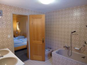 a bathroom with a sink and a tub and a toilet at Holiday Home Chalet Marietta by Interhome in Kandersteg