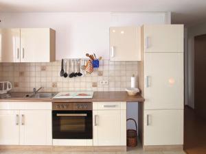 a kitchen with white cabinets and a stove top oven at Apartment Alpenblick by Interhome in Brenden