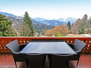 una mesa y sillas en un balcón con montañas en Apartment Le Geteillon 4 by Interhome en Chesières