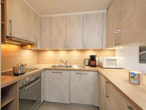 a kitchen with a sink and a microwave at Apartment Anémone 2-16 by Interhome in Arveyes