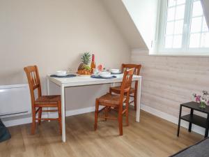 a dining room table with four chairs and a white table at Holiday Home Les Hortensias - PZV107 by Interhome in Plozévet +14 photos