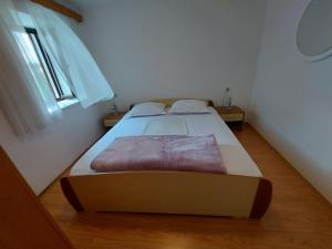 a large bed in a room with a window at Apartmani Jašarević in Martinšćica