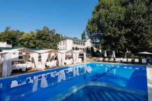 a pool at a hotel with chairs and umbrellas at Arcadia Plaza Hotel in Odesa