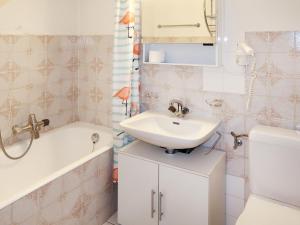 a bathroom with a sink and a tub and a toilet at Apartment Résidence Velan-24 by Interhome in Les Collons +14 photos