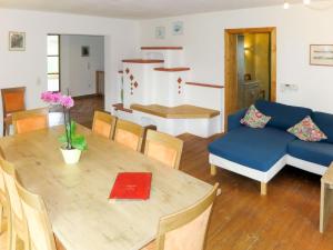 a living room with a table and a blue couch at Holiday Home Maiergschwendt by Interhome in Ruhpolding