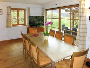 a dining room with a table and a television at Holiday Home Maiergschwendt by Interhome in Ruhpolding