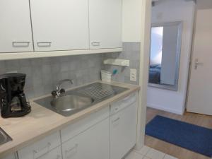 eine Küche mit weißen Schränken und einem Waschbecken in der Unterkunft Studio Galeriestudio Jungfraublick by Interhome in Interlaken