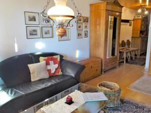 uma sala de estar com um sofá de couro preto e uma mesa em Apartment Aragon B48 by Interhome em Ernen