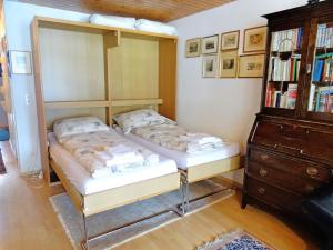 Apartment Aragon B48 by Interhome في Ernen: سريرين في غرفة نوم مع رف للكتب