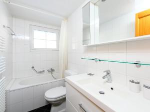 a white bathroom with a sink and a toilet at Apartment Le Mont Blanc 2 by Interhome in Villars-sur-Ollon +12 photos