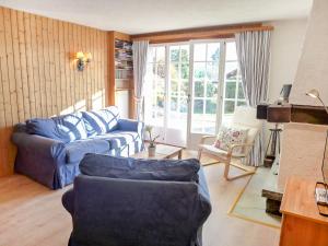 a living room with a blue couch and a chair at Apartment Le Mont Blanc 2 by Interhome in Villars-sur-Ollon
