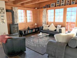 a living room with two couches and a fireplace at Apartment Chalet Eiger-2 by Interhome in Grindelwald