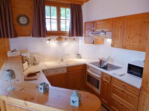 - une cuisine avec des placards en bois et un comptoir dans l'établissement Apartment Le Faucon 7 by Interhome, à Villars-sur-Ollon