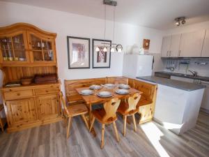 a kitchen with a wooden table and chairs at Apartment Les Bouillets by Interhome in Veysonnaz