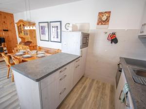 a kitchen with a white refrigerator and a table at Apartment Les Bouillets by Interhome in Veysonnaz +14 photos