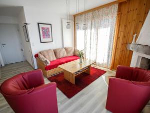 a living room with a red couch and a table at Apartment Les Bouillets by Interhome in Veysonnaz