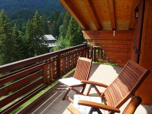two chairs sitting on the balcony of a cabin at Apartment Le Faucon 7 by Interhome in Villars-sur-Ollon