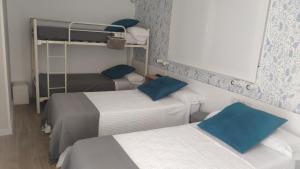 a room with two beds with blue pillows at PortoSantiago in Portomarin