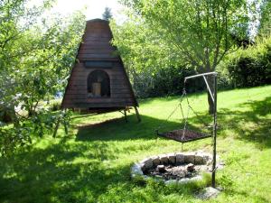 a dog house and a swing in a yard at Apartment Janik by Interhome in Bischofsmais