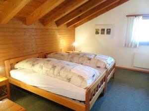 - 2 lits dans une chambre dotée de murs en bois dans l'établissement Apartment Aragon T100 by Interhome, à Fiesch