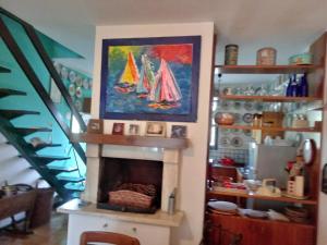 a living room with a fireplace with a painting of sailboats at RESIDENZA DI SANDRA in Isola Albarella