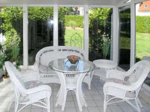 einen weißen Glastisch und Stühle auf einer Veranda in der Unterkunft Holiday Home Alexorella by Interhome in Godern