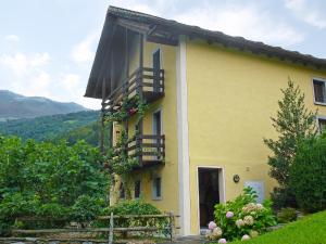 a yellow house with flower boxes and a balcony at Apartment Nelly by Interhome in Ponto Valentino