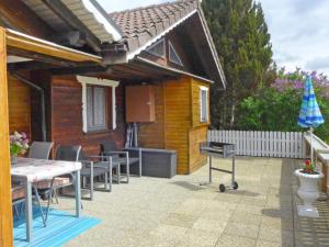 un patio con mesas y sillas frente a una casa en Chalet Hügli by Interhome, en Bure