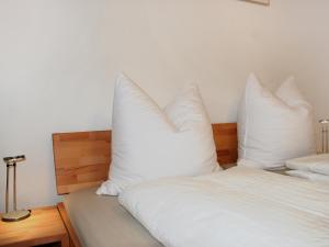 - 2 lits avec des oreillers blancs l'un sur l'autre dans l'établissement Apartment Valetta Sura by Interhome, à Flims