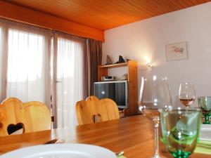 ein Esszimmer mit einem Tisch und Weingläsern darauf in der Unterkunft Apartment Valetta Sura by Interhome in Flims