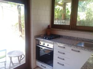 eine Küche mit Herd und Spüle in der Unterkunft Agua Azul poolside rest a luxurious rural woodland idyll in Cabeçadas