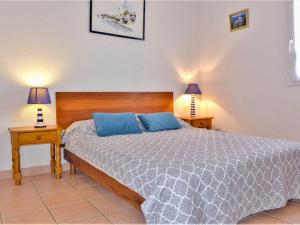 Un dormitorio con una cama con almohadas azules y dos lámparas. en Holiday Home Les Jardins de la Clape-1 by Interhome, en Narbonne-Plage