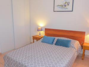 Un dormitorio con una cama con dos almohadas azules. en Holiday Home Les Jardins de la Clape-1 by Interhome, en Narbonne-Plage 15 fotos más