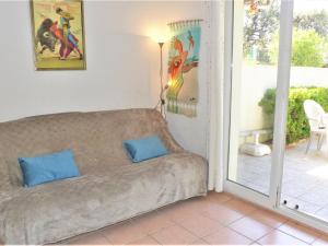 ein Sofa im Wohnzimmer mit Glasschiebetür in der Unterkunft Holiday Home Les Jardins de la Clape by Interhome in Narbonne-Plage