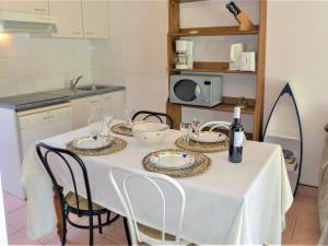 una mesa blanca con sillas y un mantel blanco en Holiday Home Les Jardins de la Clape-1 by Interhome, en Narbonne-Plage